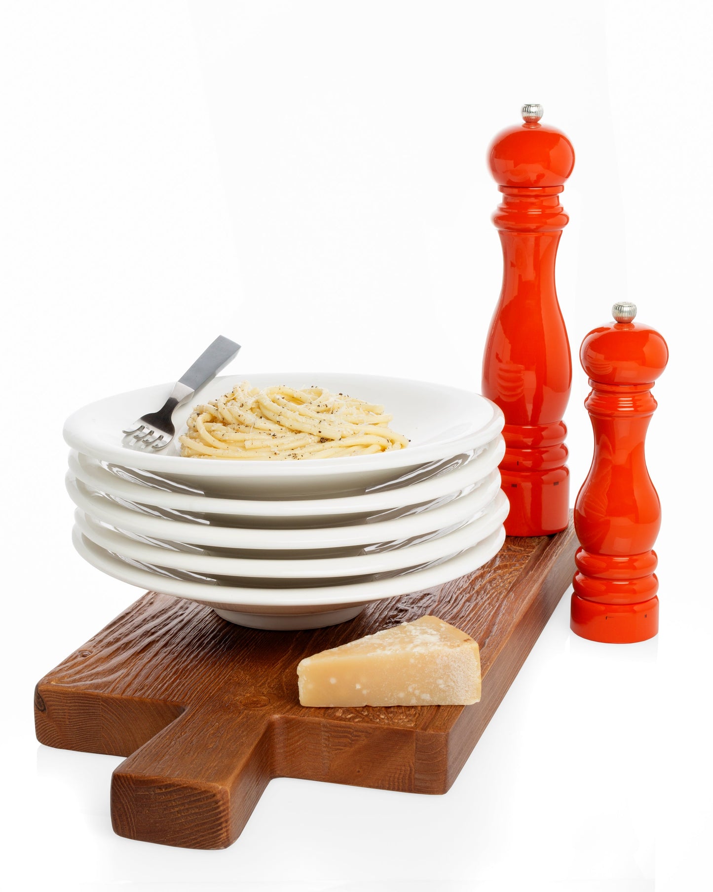 white ceramic bowl with International orange salt and pepper mills
